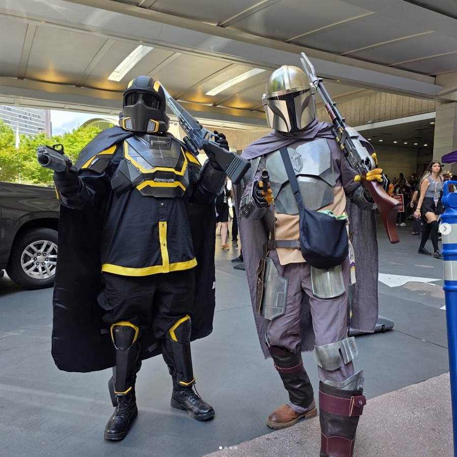 Two people in elaborate costumes resembling characters from a popular franchise, standing outdoors.